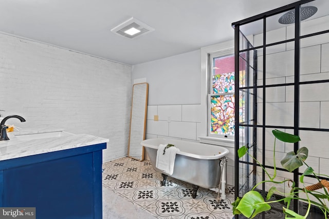 bathroom featuring a freestanding bath, vanity, tile walls, and a tile shower