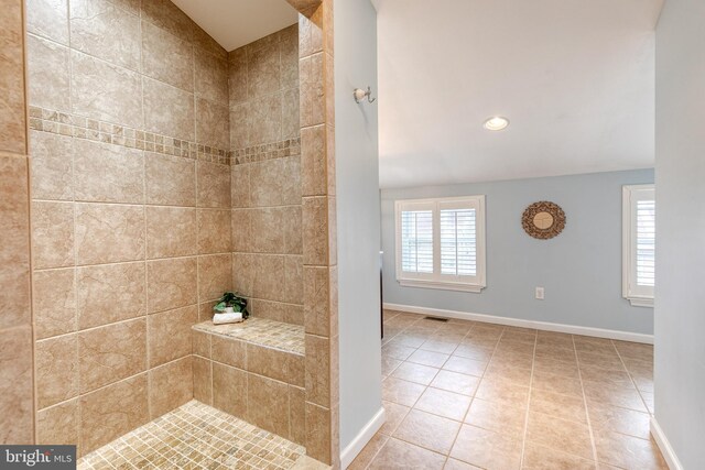 full bath featuring tile patterned flooring, tiled shower, visible vents, and baseboards