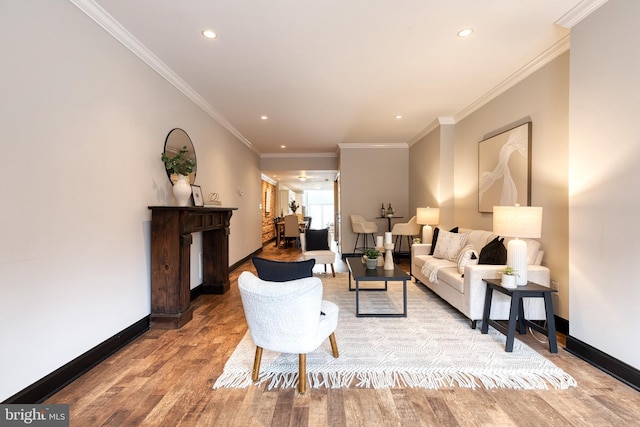 living area with crown molding, recessed lighting, light wood-style flooring, and baseboards