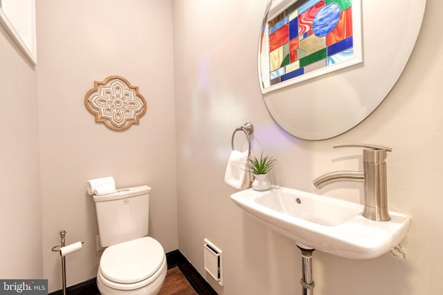 bathroom featuring toilet, baseboards, visible vents, and a sink