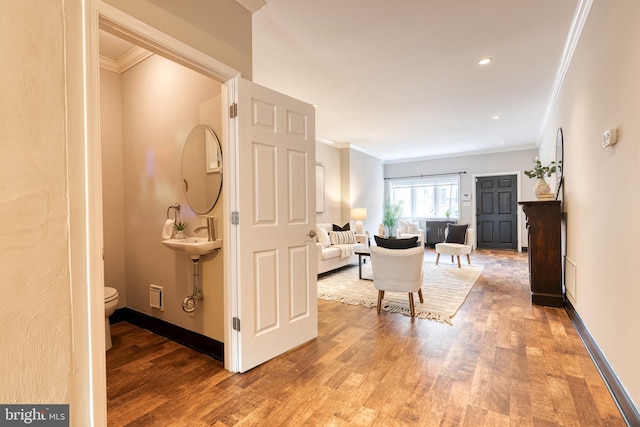 corridor with baseboards, recessed lighting, wood finished floors, and crown molding