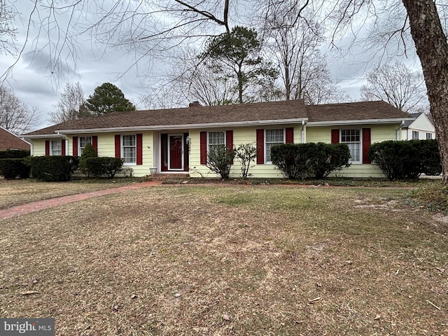 ranch-style home with a front lawn and a chimney