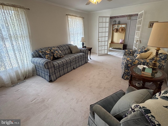 living room with carpet floors, a ceiling fan, crown molding, and french doors