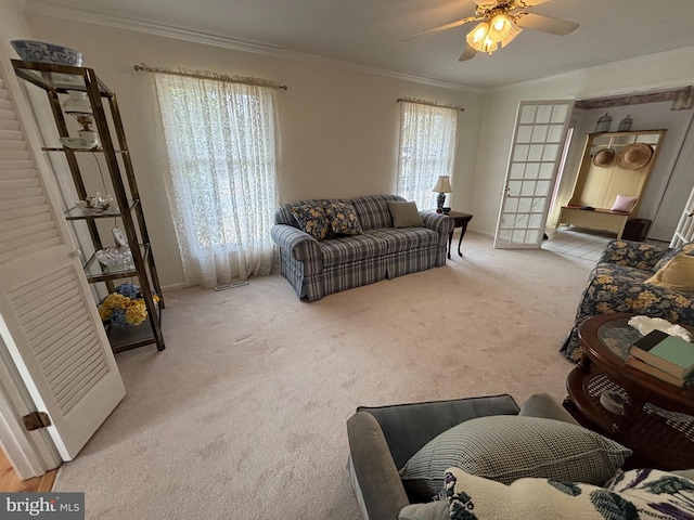 carpeted living area featuring a healthy amount of sunlight, crown molding, and ceiling fan