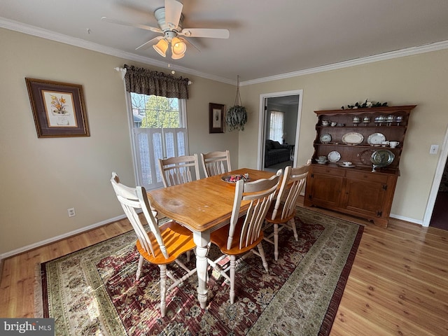 dining area with light wood-style flooring, baseboards, ceiling fan, and crown molding