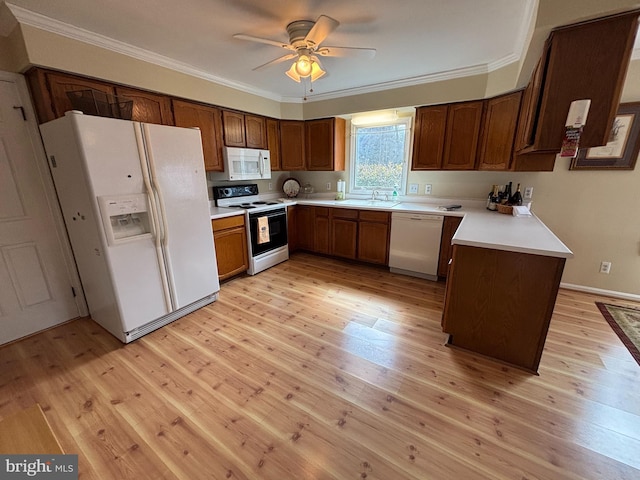 kitchen with white appliances, light wood-type flooring, a sink, and crown molding