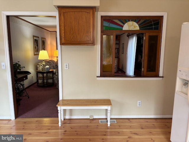 kitchen with baseboards, visible vents, brown cabinetry, and wood finished floors