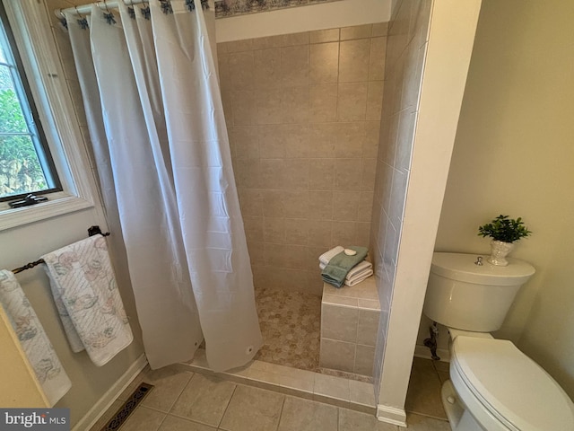 full bathroom featuring tile patterned flooring, visible vents, toilet, and tiled shower