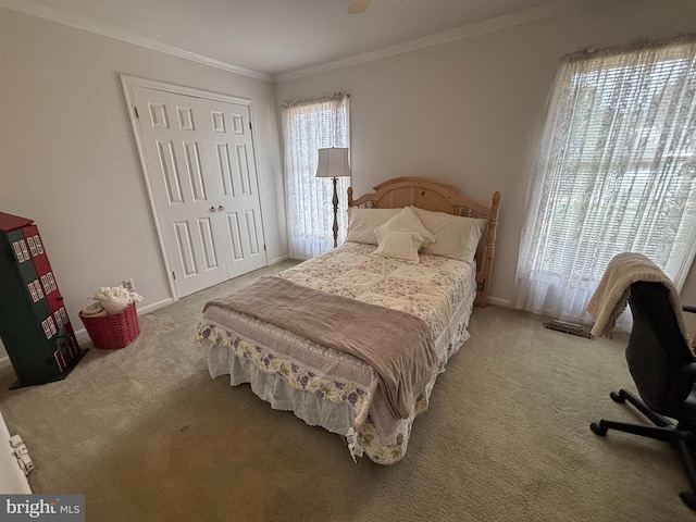 carpeted bedroom featuring ornamental molding, a closet, and baseboards