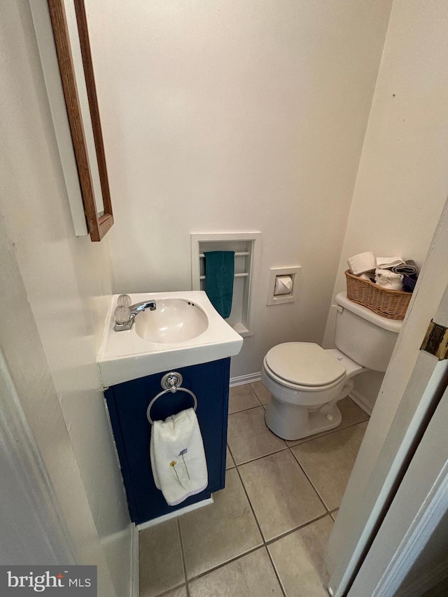 bathroom with vanity, tile patterned flooring, toilet, and baseboards