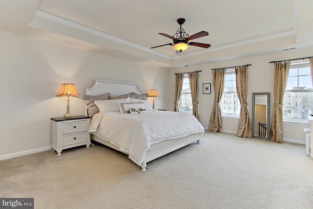 bedroom with a raised ceiling, ornamental molding, and carpet flooring