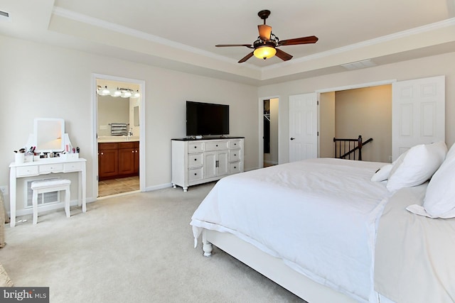 bedroom featuring crown molding, light colored carpet, a tray ceiling, and a spacious closet