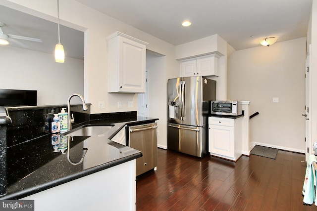 kitchen with pendant lighting, sink, appliances with stainless steel finishes, dark hardwood / wood-style floors, and white cabinets