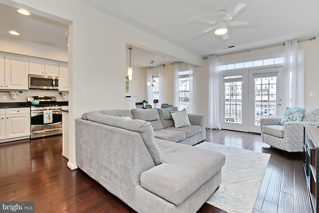 living room with dark hardwood / wood-style flooring and ceiling fan