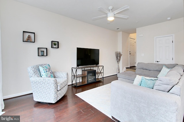 living room featuring ceiling fan and dark hardwood / wood-style flooring