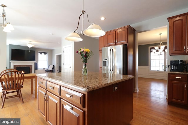 kitchen with hanging light fixtures, a center island, and stainless steel fridge with ice dispenser