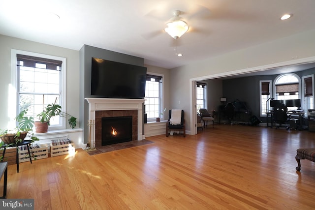 unfurnished living room featuring a fireplace, recessed lighting, ceiling fan, wood finished floors, and baseboards