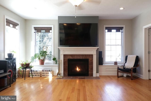 sitting room featuring a fireplace, baseboards, wood finished floors, and recessed lighting