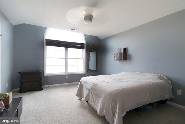 bedroom featuring light carpet, ceiling fan, vaulted ceiling, and baseboards