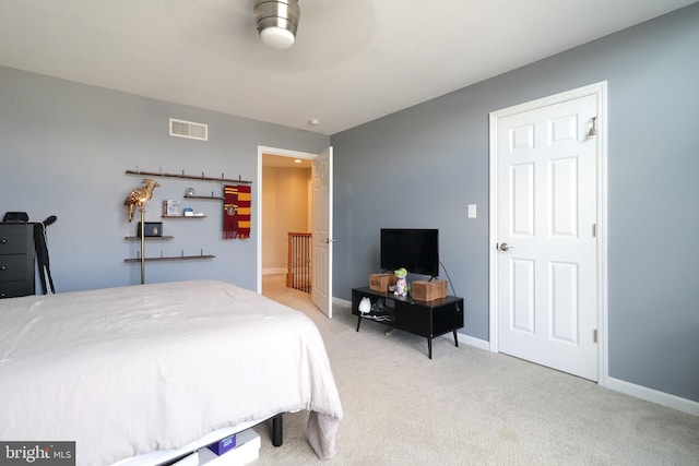 bedroom with baseboards, visible vents, and light colored carpet