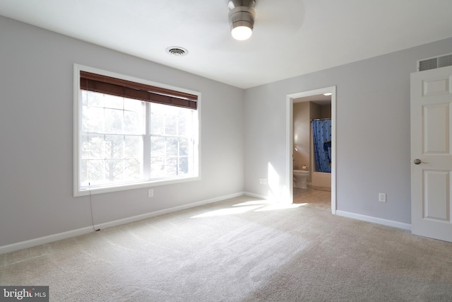 unfurnished room featuring baseboards, visible vents, and light colored carpet