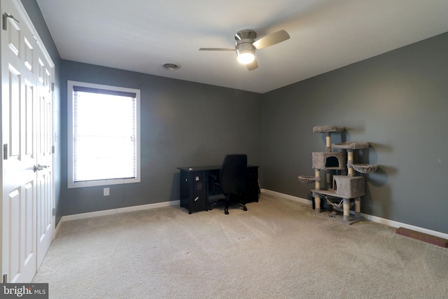 office area featuring light carpet, baseboards, visible vents, and a ceiling fan