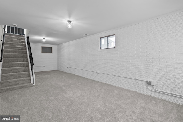 basement featuring brick wall and carpet floors