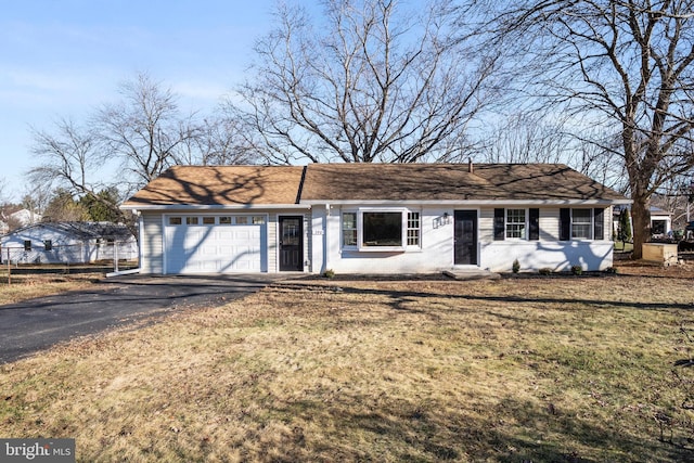 ranch-style house featuring a garage and a front lawn