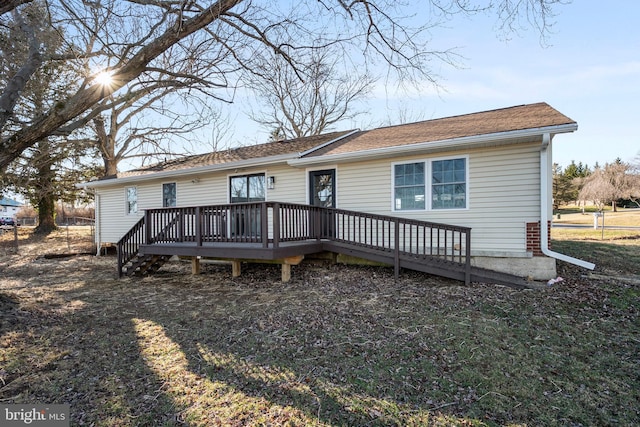 rear view of house featuring a wooden deck