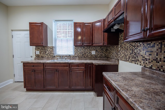 kitchen featuring tasteful backsplash, light tile patterned flooring, and sink