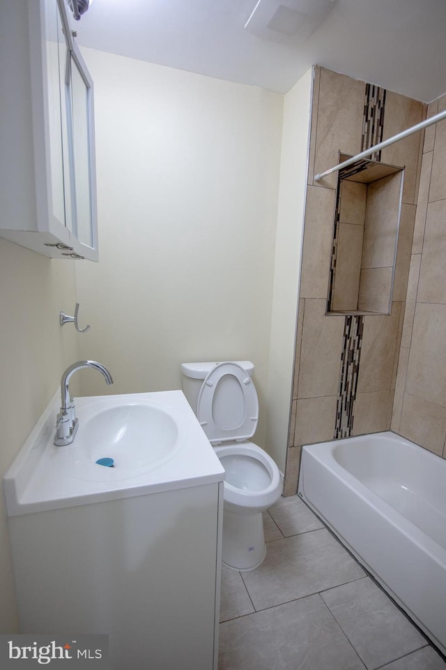 full bathroom featuring tile patterned flooring, tiled shower / bath, vanity, and toilet