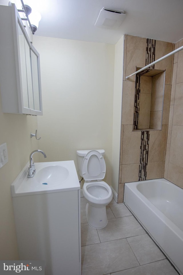 full bathroom with tiled shower / bath, vanity, toilet, and tile patterned floors