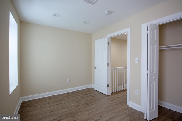 unfurnished bedroom featuring hardwood / wood-style floors and a closet