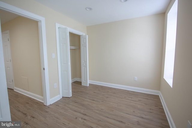 unfurnished bedroom with a closet and light hardwood / wood-style flooring