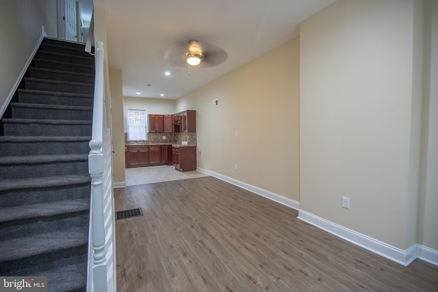 staircase featuring hardwood / wood-style floors and ceiling fan