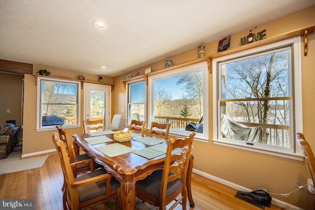 dining space with a textured ceiling and light wood-type flooring