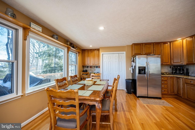 dining space featuring light hardwood / wood-style floors and a textured ceiling