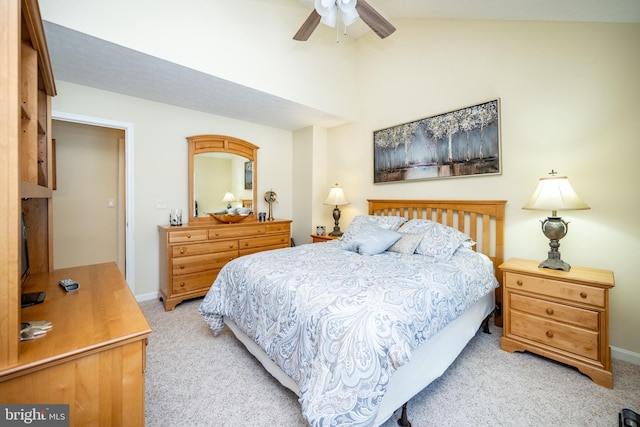 bedroom with vaulted ceiling, light colored carpet, and ceiling fan