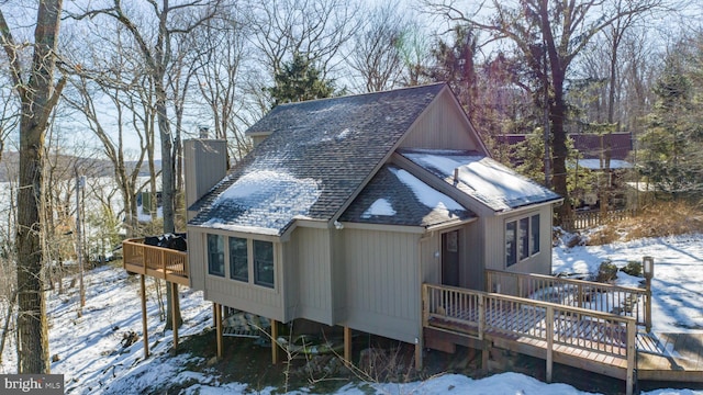 snow covered house with a wooden deck