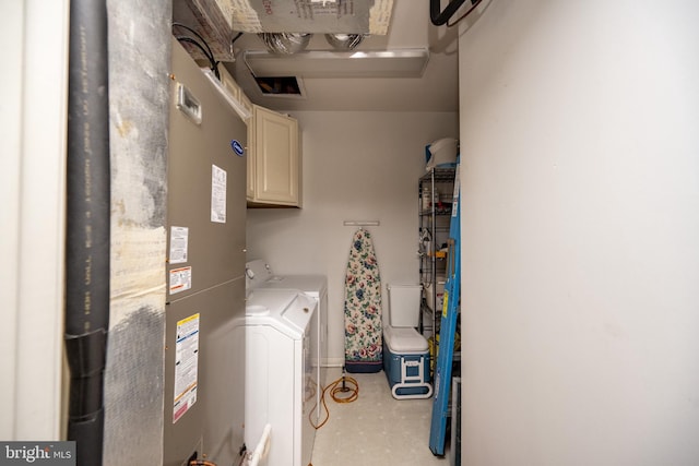 clothes washing area with cabinets and separate washer and dryer