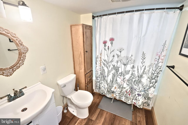 full bath featuring a shower with curtain, toilet, wood finished floors, and vanity