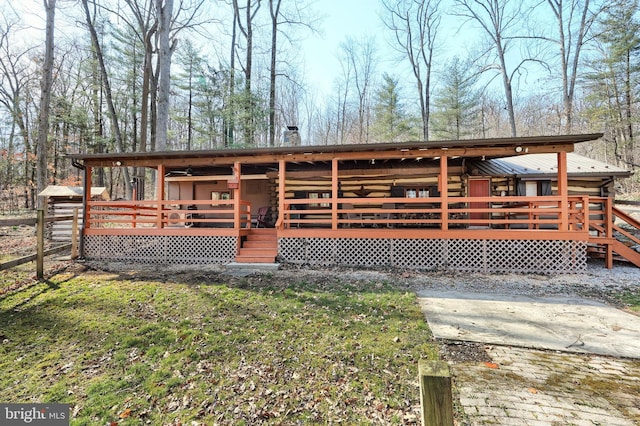 view of front of property featuring a wooden deck and log exterior