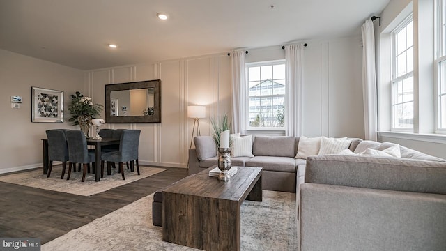 living room featuring dark wood-type flooring and a wealth of natural light