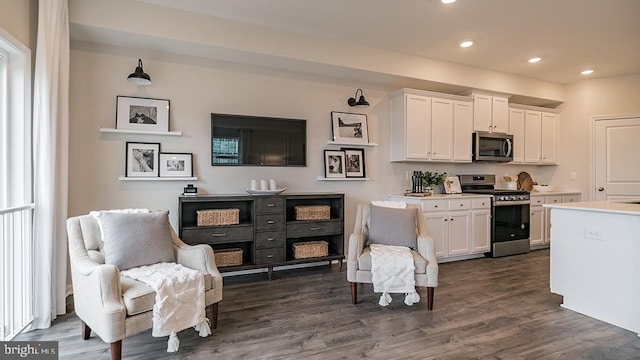 kitchen with appliances with stainless steel finishes, dark hardwood / wood-style flooring, and white cabinets