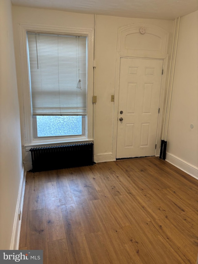 foyer featuring wood-type flooring and radiator