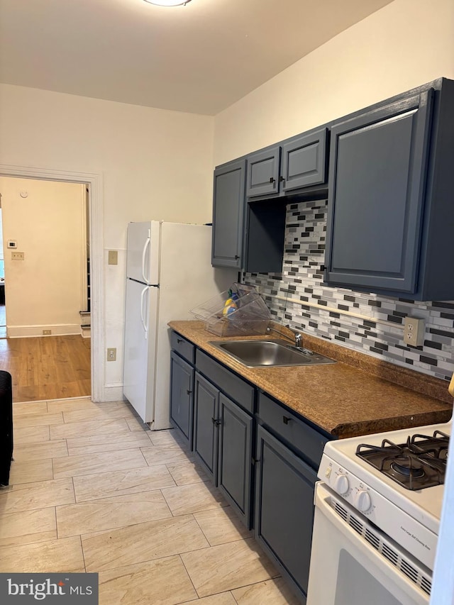 kitchen featuring sink, backsplash, and white appliances