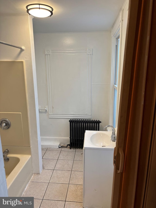 bathroom featuring washtub / shower combination, vanity, radiator, and tile patterned flooring