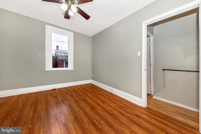 empty room with hardwood / wood-style floors and ceiling fan