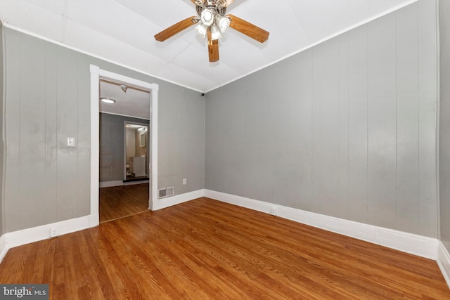 unfurnished room with crown molding, wood-type flooring, and ceiling fan