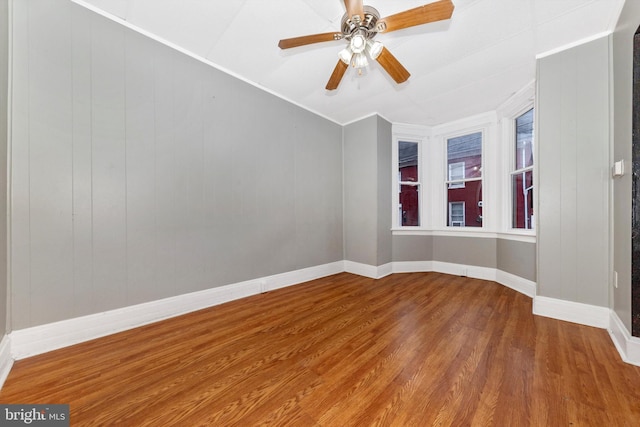 spare room with ceiling fan, crown molding, vaulted ceiling, and wood-type flooring